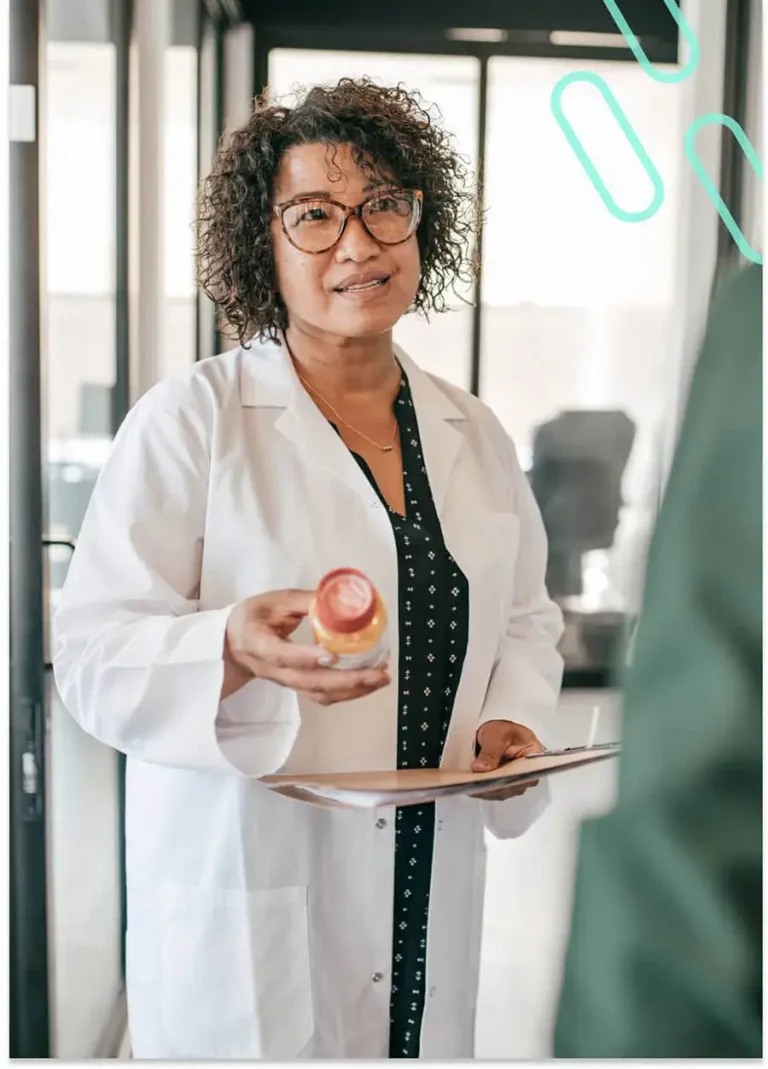 Image of a pharmacist holding a prescription and a patient's folder while in discussion.