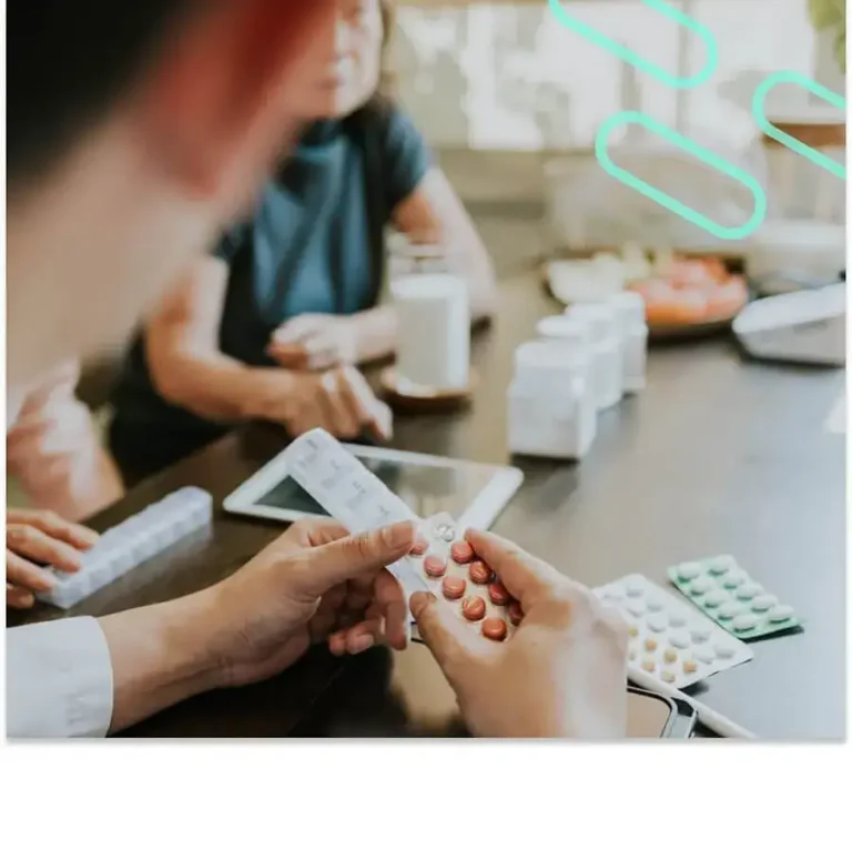 An image of a pharmacy professional holding a prescription and discussing it with two adults.