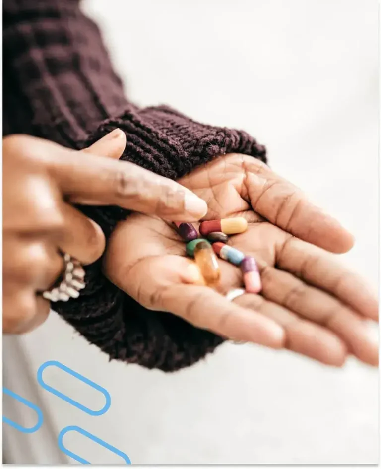 An image of a lady sorting through a handful of prescription pills.