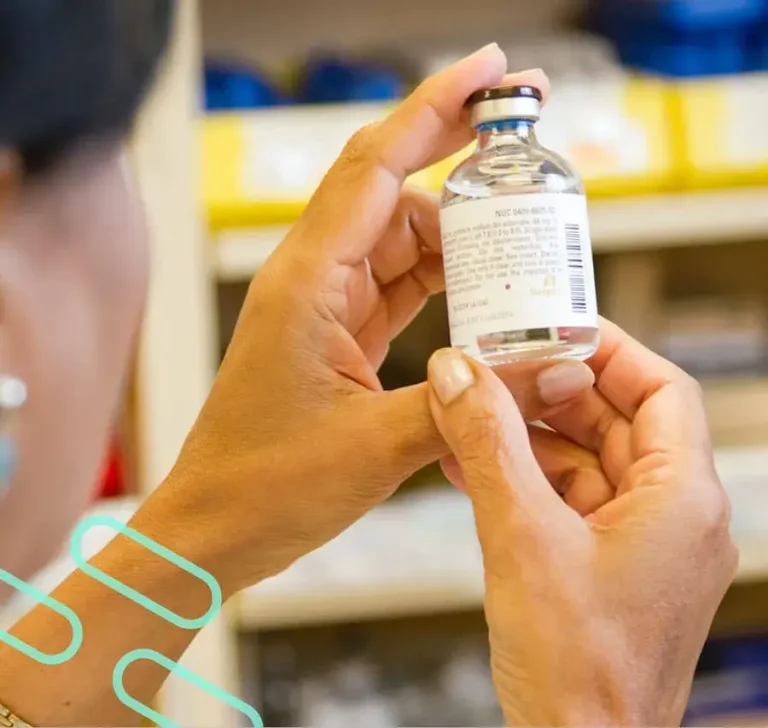 An image of a pharmacist examining a liquid prescription bottle.